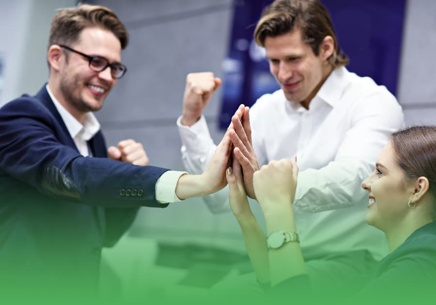 two male business professional brokers and one female professional high-fiving each other