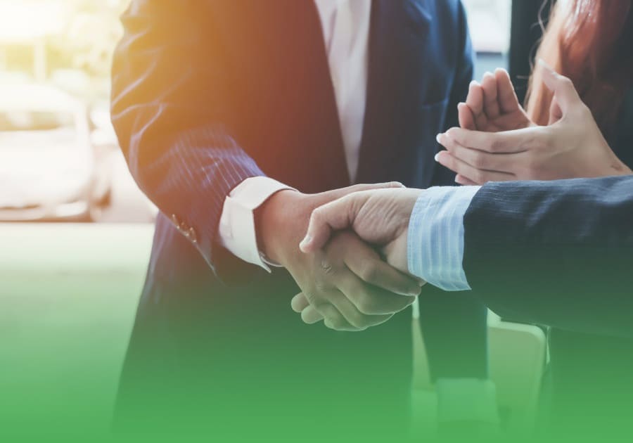 two business investors in shaking hands and a business woman clapping