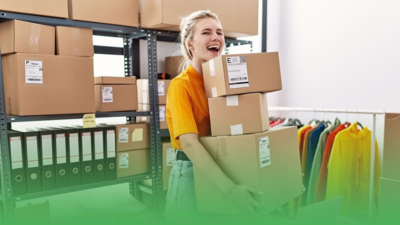 Female e-commerce business owner carrying boxes in warehouse.