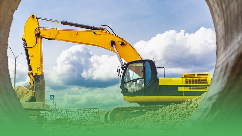 Yellow excavator operated by excavation business owner digs into ground with precision.