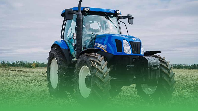 Blue tractor parked in field representing farm equipment business.