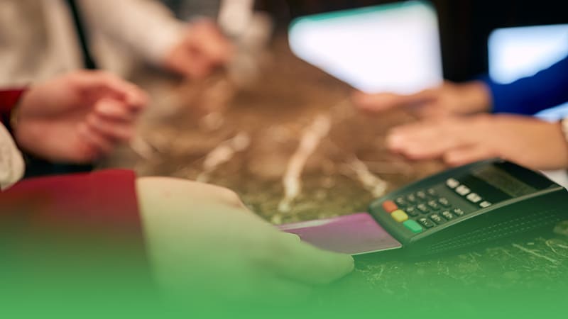 Customer paying for hotel services with credit card at front desk.